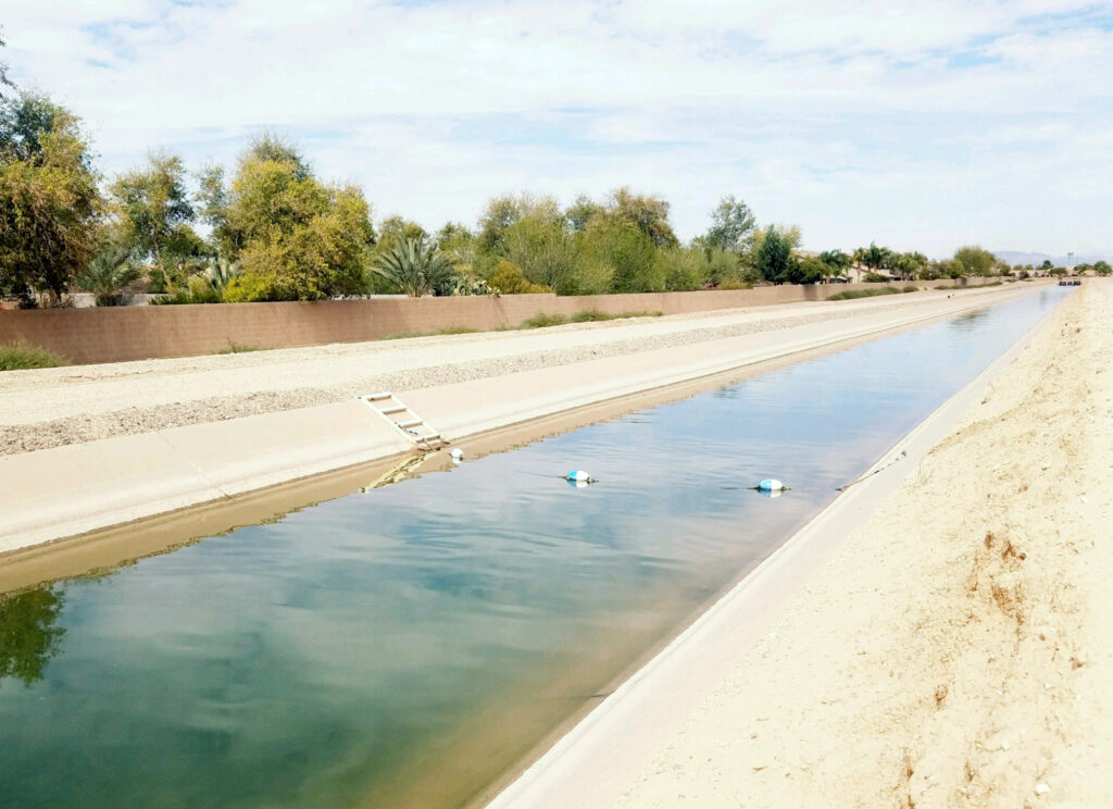 Photo of a canal with clear water in an arid landscape