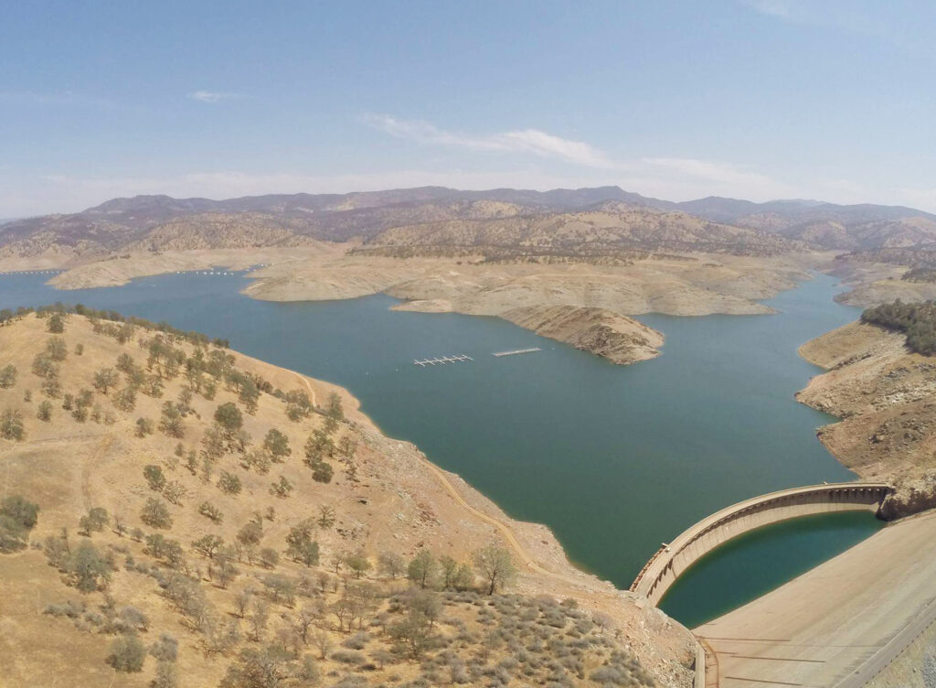 Photo of Lake McClure during a drought. The original Exchequer Dam, normally submerged, is exposed.
