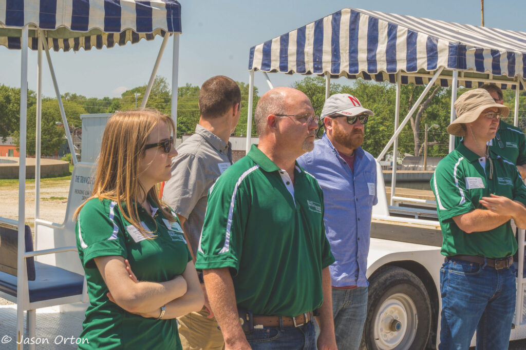 Photo of small group of people standing n front of golf carts